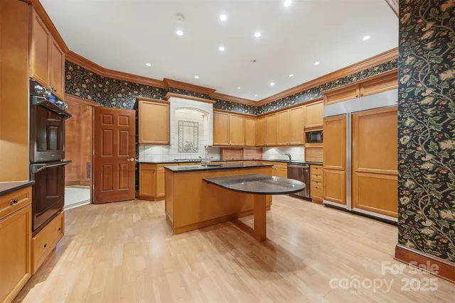 a kitchen with stainless steel appliances granite countertop a refrigerator a sink and a stove