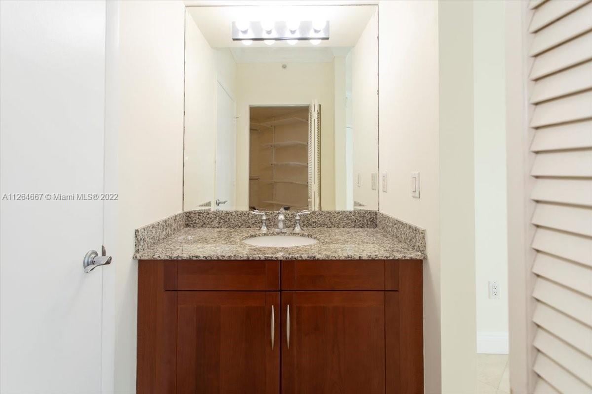 7275 Southwest 90th Street, Unit C310 Miami, FL 33156 - Photo 30 of 40 a bathroom with a granite countertop sink and a mirror