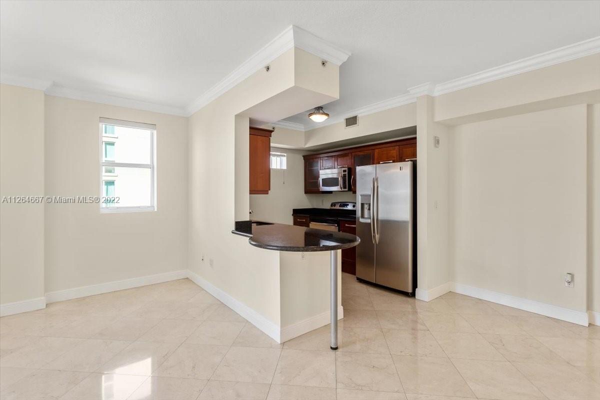 7275 Southwest 90th Street, Unit C310 Miami, FL 33156 - Photo 6 of 40 a kitchen with cabinets and stainless steel appliances