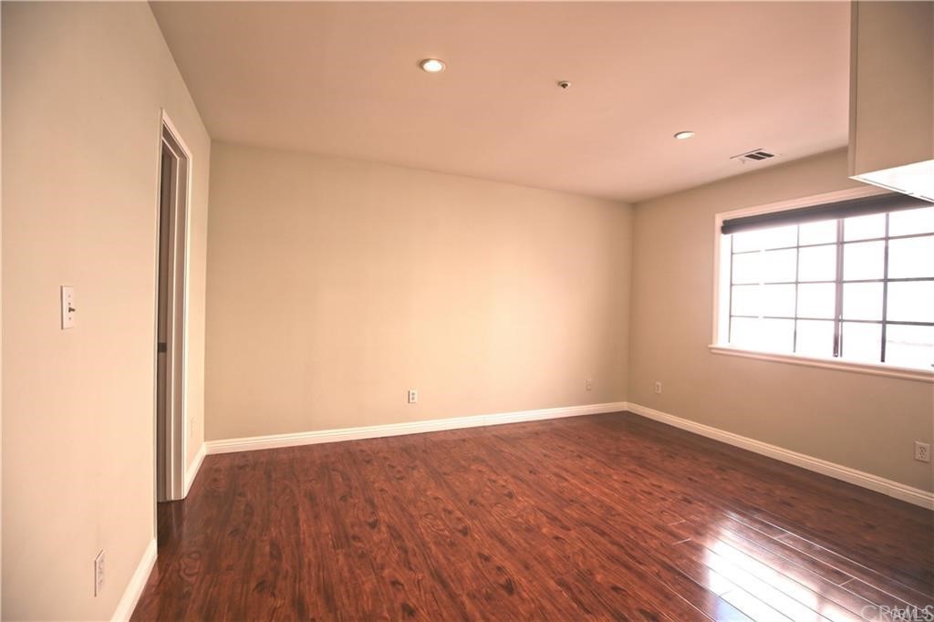 105 East Beacon Street, Unit A Alhambra, CA 91801 - Photo 12 of 15 an empty room with wooden floor and windows