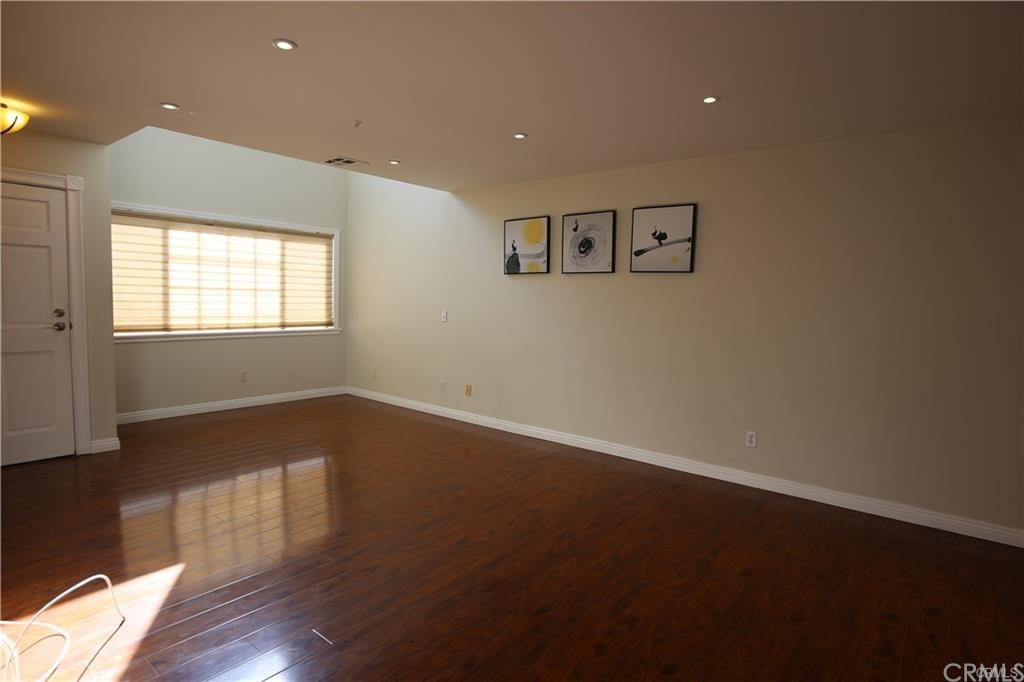 105 East Beacon Street, Unit A Alhambra, CA 91801 - Photo 2 of 15 an empty room with wooden floor and windows