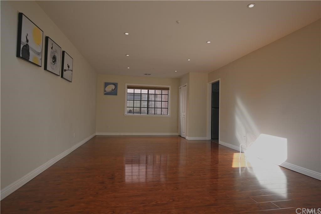 105 East Beacon Street, Unit A Alhambra, CA 91801 - Photo 3 of 15 a view of an empty room with wooden floor and a window