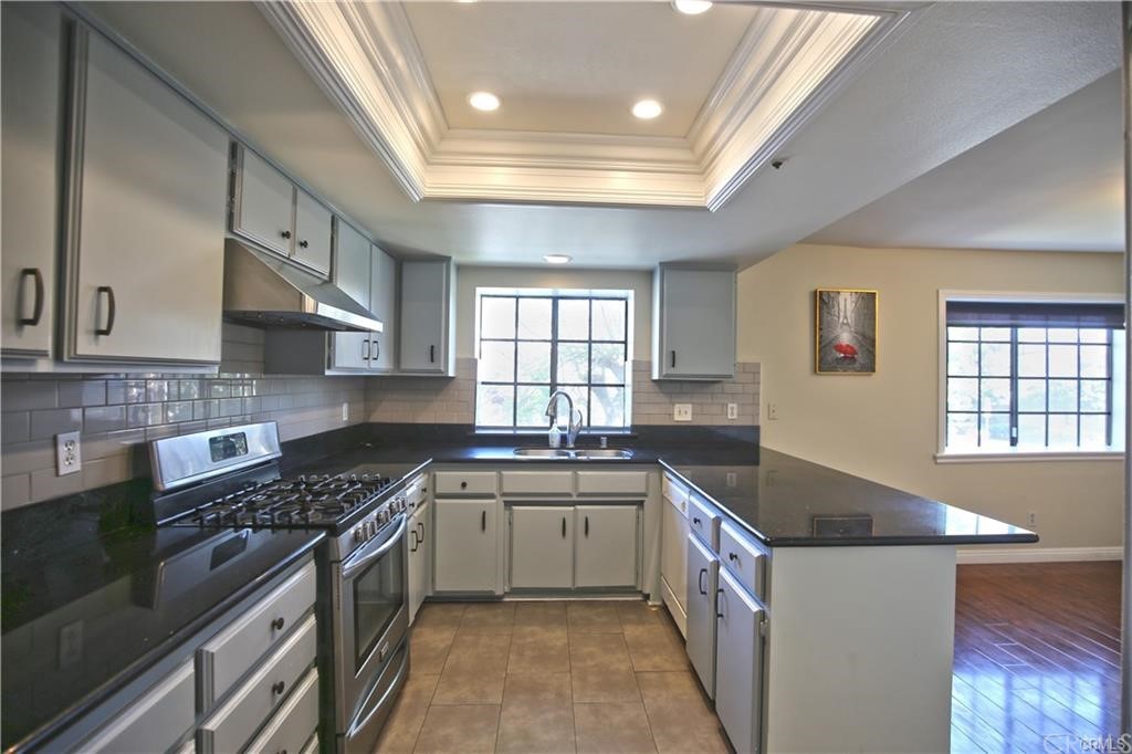 105 East Beacon Street, Unit A Alhambra, CA 91801 - Photo 5 of 15 a kitchen with stainless steel appliances a sink stove and cabinets