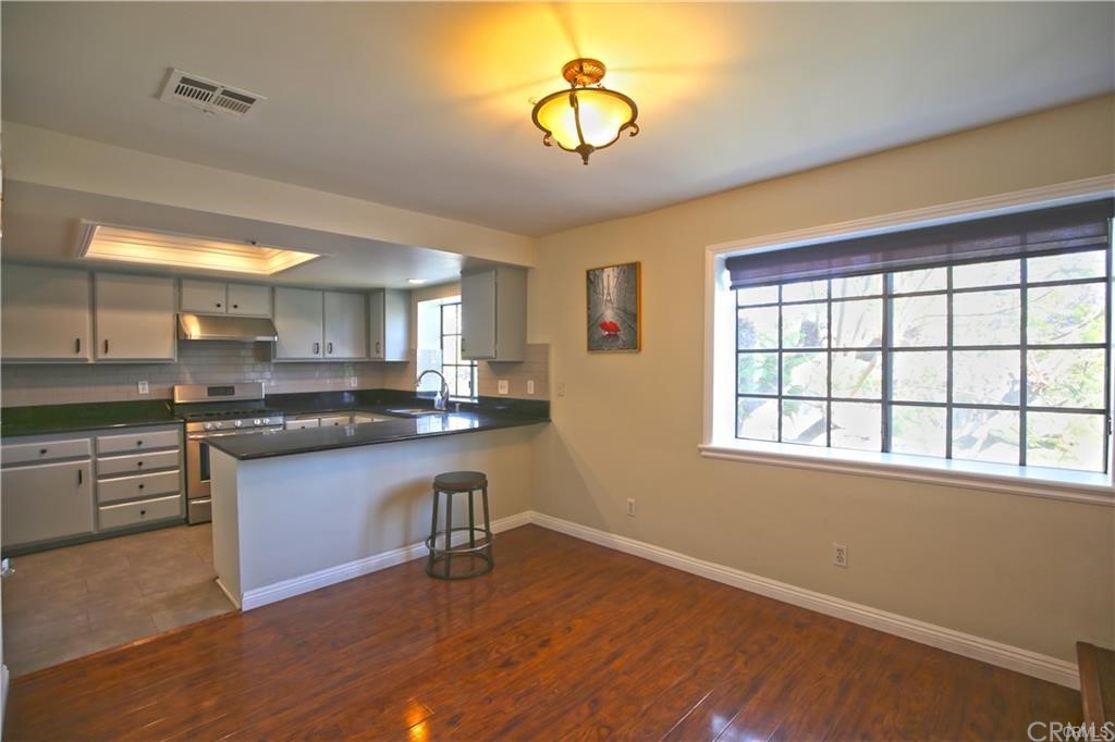 105 East Beacon Street, Unit A Alhambra, CA 91801 - Photo 6 of 15 a kitchen with stainless steel appliances granite countertop a stove a sink and a microwave