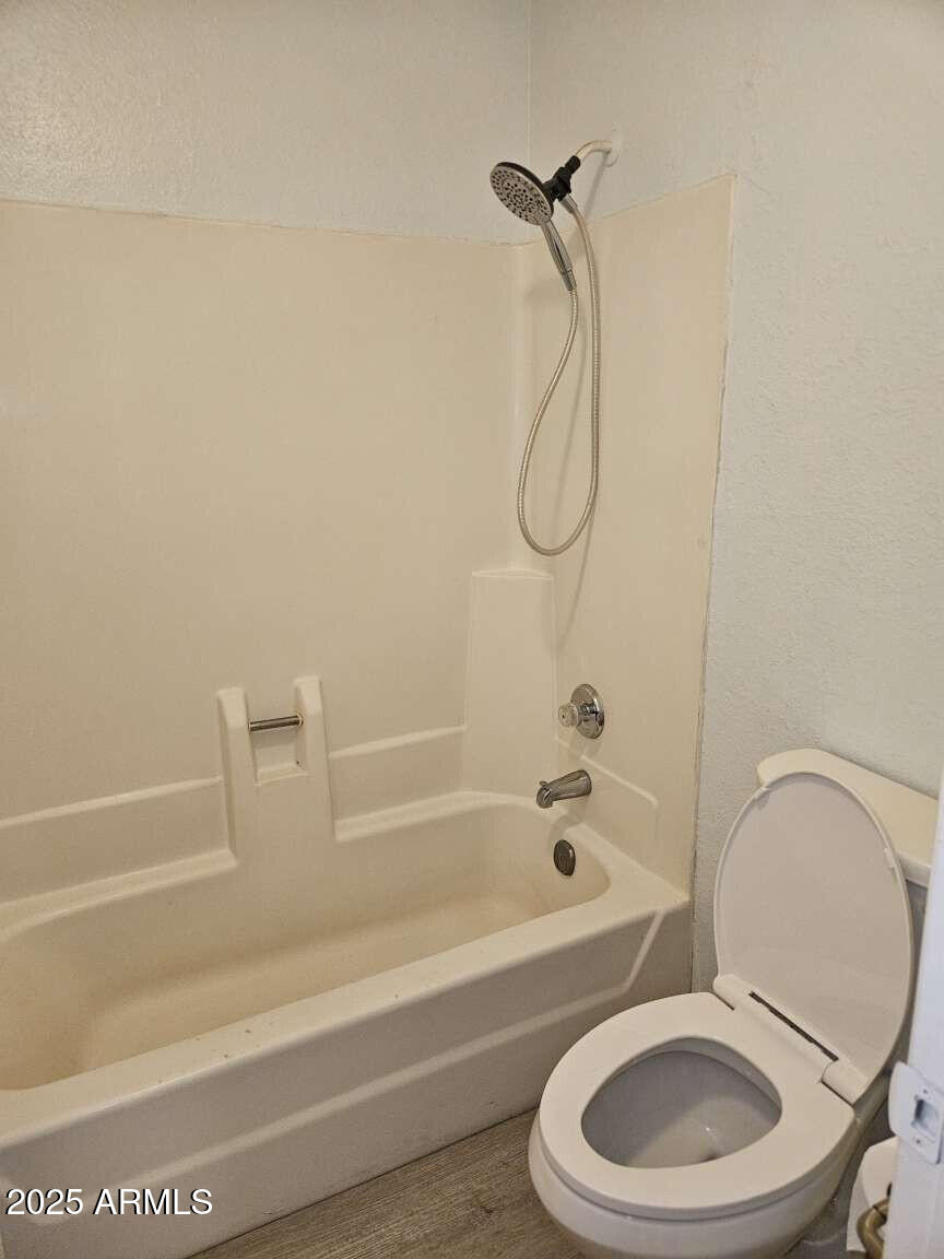 2220 West Dora Street, Unit 114 Mesa, AZ 85201 - Photo 13 of 17 a bathroom with a toilet and a bath tub