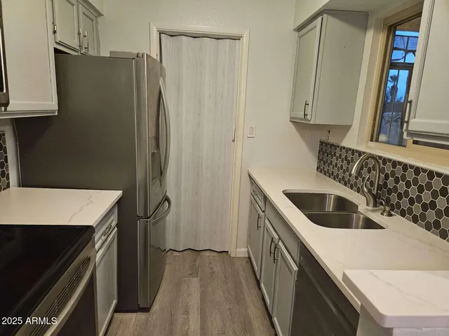 a kitchen with a sink a refrigerator and cabinets