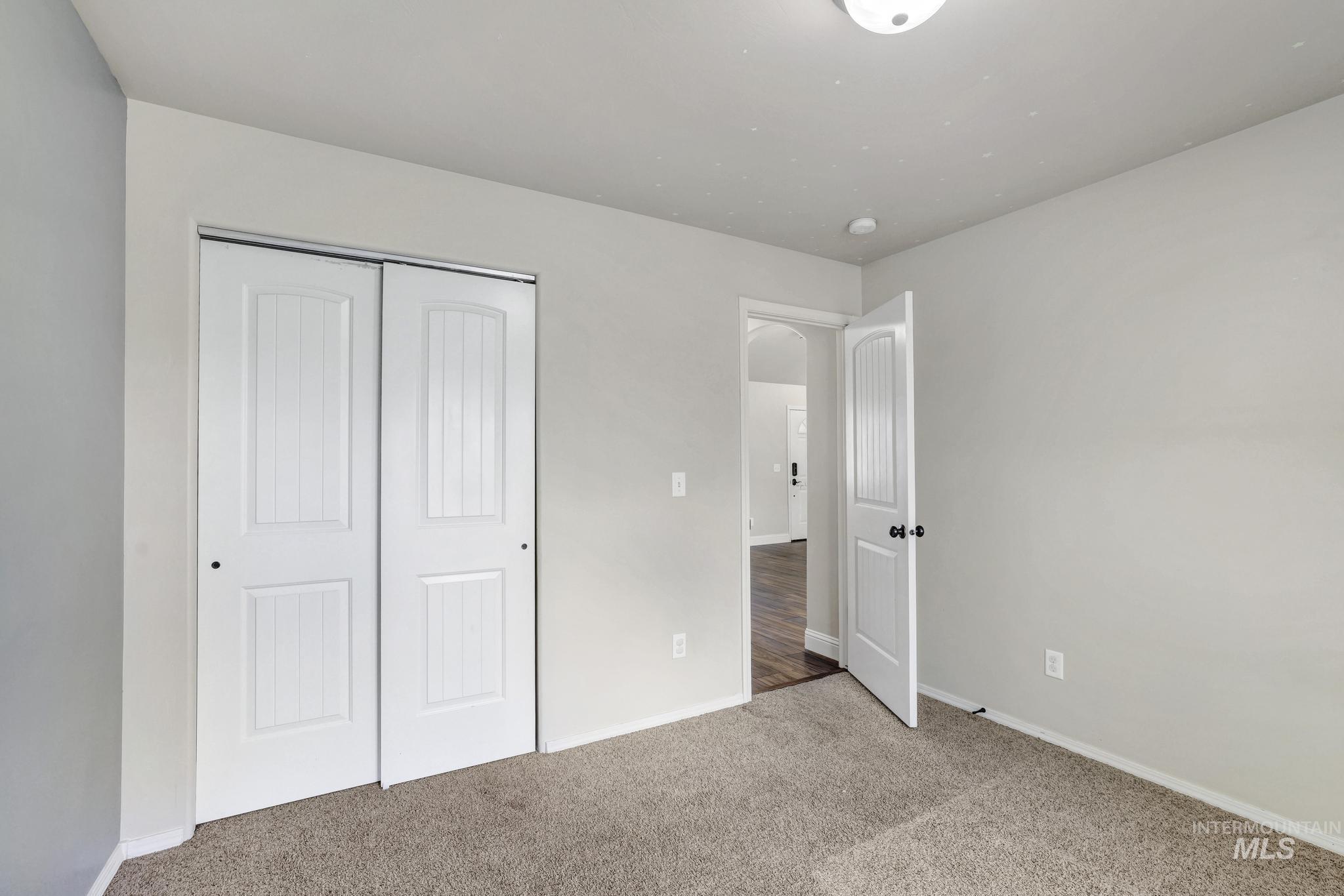 446 Noble Street Twin Falls, ID 83301 - Photo 13 of 42 Room featuring neutral carpeting, light-colored walls, and a white bi-fold closet door with paneling details