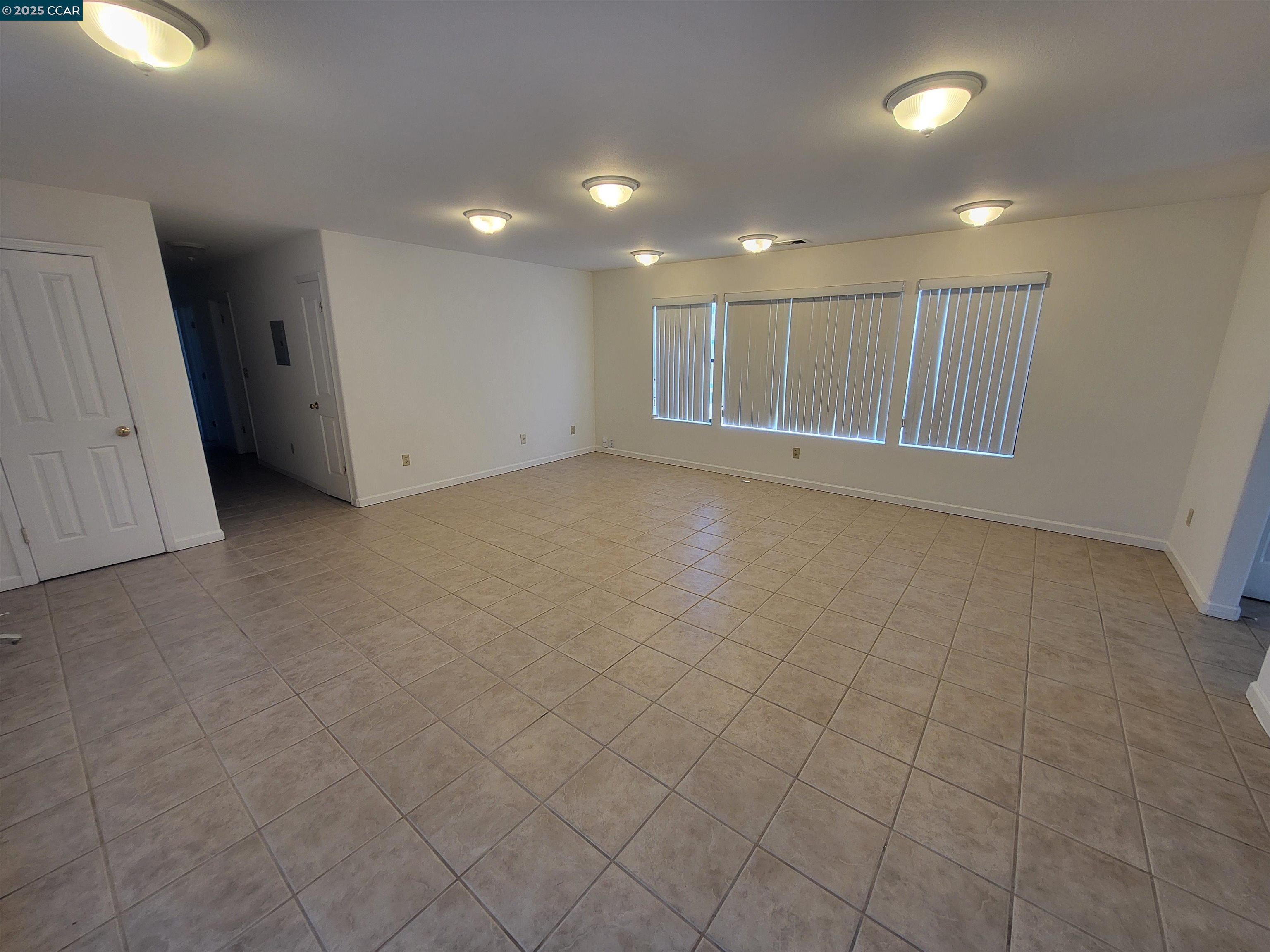 526 Harbour Way Richmond, CA 94801 - Photo 4 of 15 an empty room with a ceiling fan and window