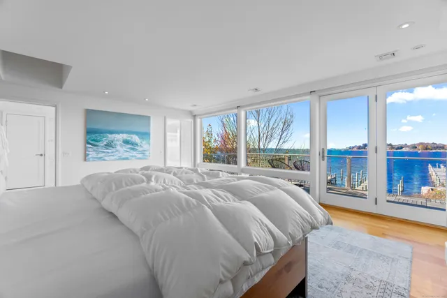 a bed sitting in a spacious bedroom next to a window