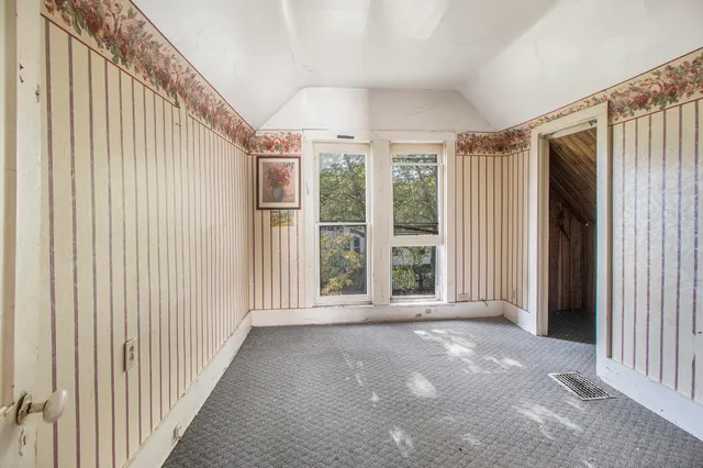 a view of a big room with wooden floor stairs and windows