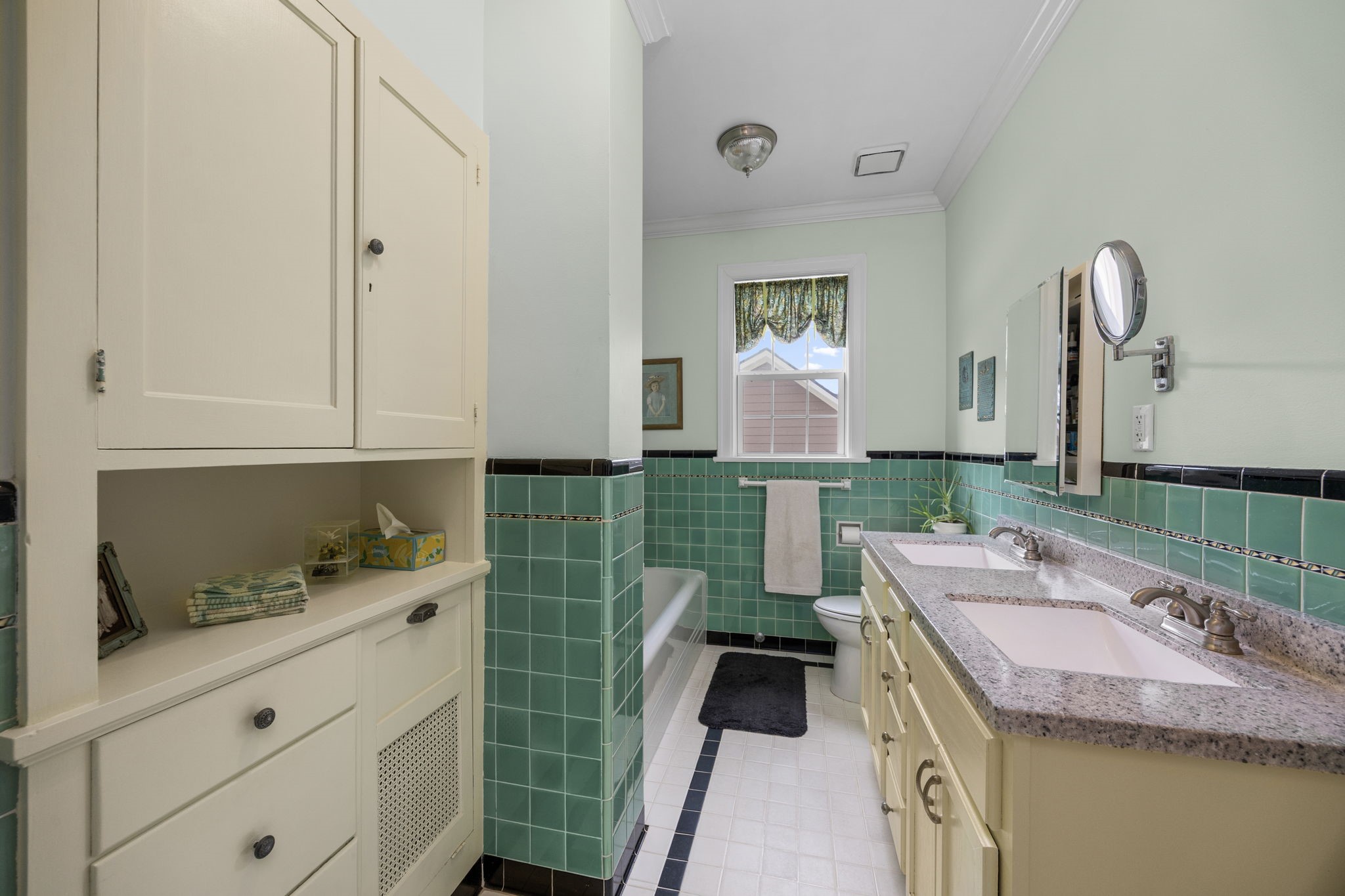801 West Main Street Brenham, TX 77833 - Photo 29 of 50 The upstairs primary ensuite offers dual sinks, generous counter space, and abundant built in cabinetry for storage. Vintage inspired tilework adds character.