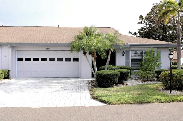 a view of a white house with a large window and potted plants