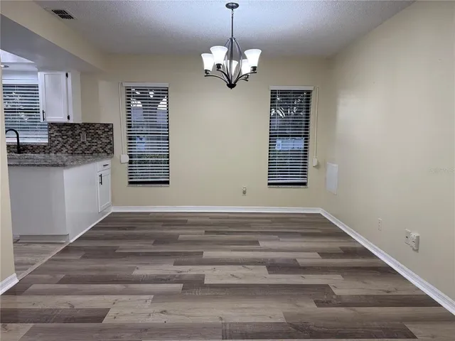 a view of an empty room with window and cabinet