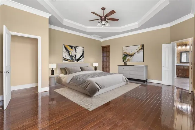 a spacious bedroom with a large bed a chandelier and closet