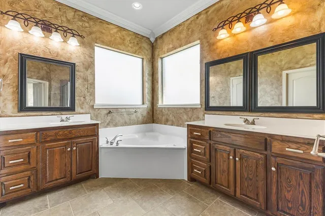 a bathroom with a granite countertop sink mirror and a bathtub next to a window