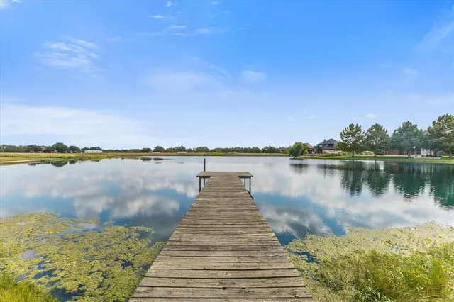 a wooden pier with boats in a lake