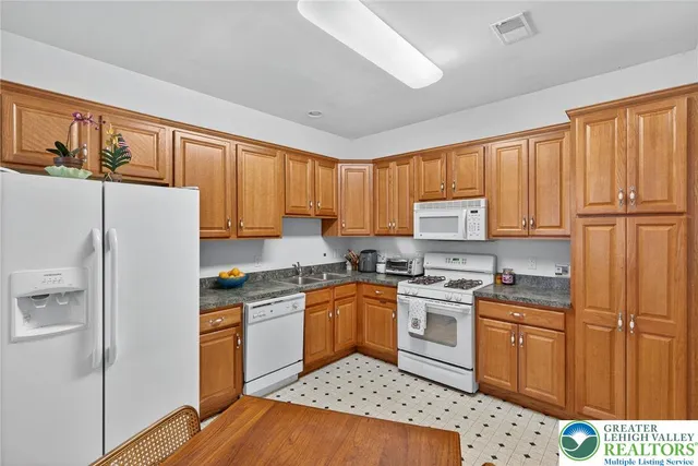 a kitchen with a refrigerator stove top oven and sink