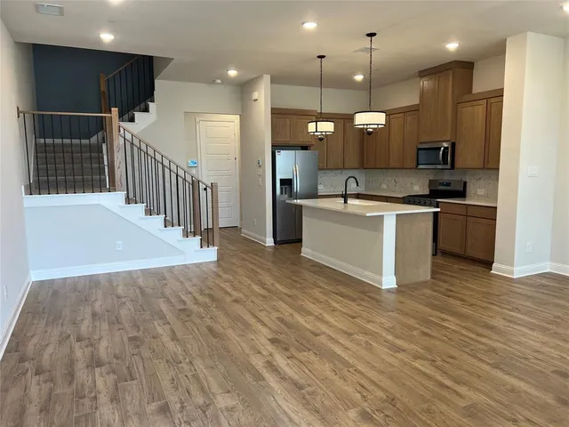 a large kitchen with kitchen island a sink stainless steel appliances and a counter top