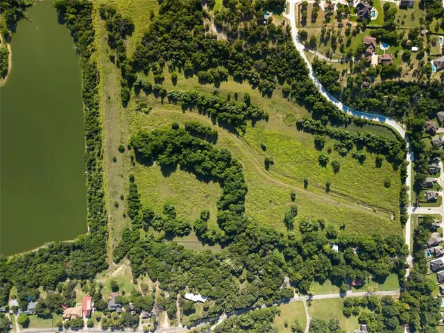 an aerial view of residential houses with outdoor space and trees