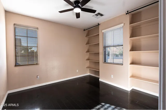 a room with a hardwood floor and a ceiling fan