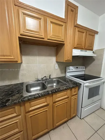a kitchen with granite countertop a sink and cabinets