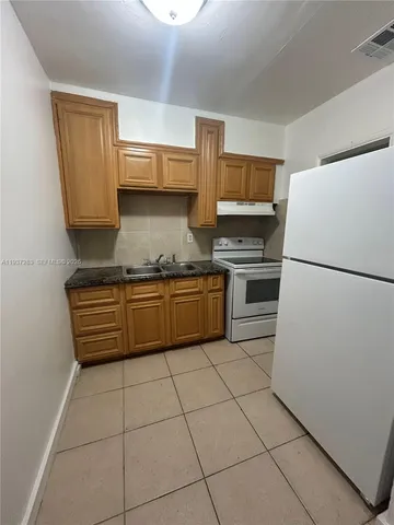 a kitchen with a stove a refrigerator and a sink