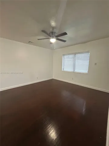 an empty room with a ceiling fan and a window