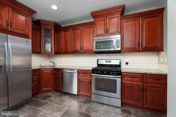 a kitchen with stainless steel appliances granite countertop a stove top oven a sink dishwasher and granite countertops