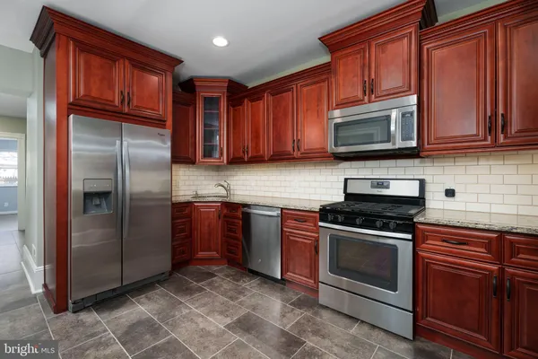 a kitchen with stainless steel appliances granite countertop a refrigerator stove top oven a sink and dishwasher