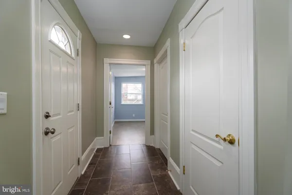 a view of a hallway with a livingroom and a bathroom with sink