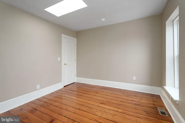 wooden floor in an empty room with a window