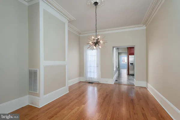 a view of a room with wooden floor chandelier and closet