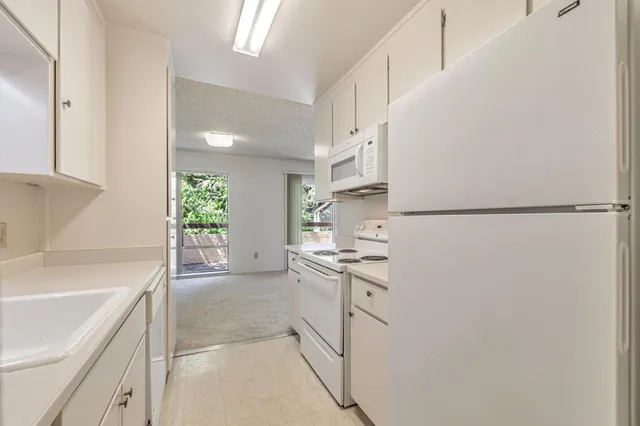 a kitchen with white cabinets and white appliances