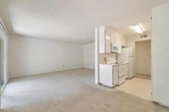 a view of a kitchen with white cabinets
