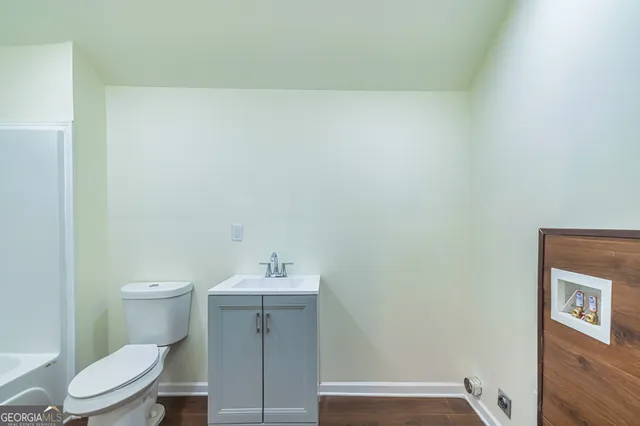 a bathroom with a toilet a sink and mirror