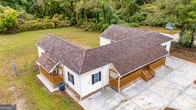 an aerial view of a house with a yard swimming pool and outdoor seating