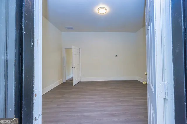 a view of an empty room with wooden floor
