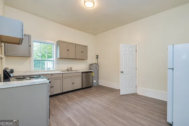 a kitchen with sink cabinets and wooden floor