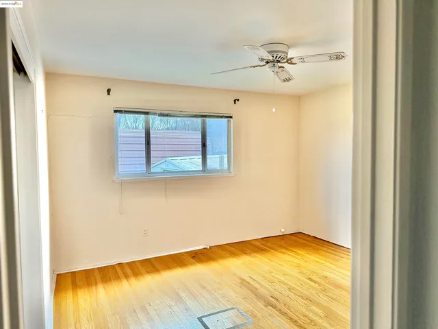 a view of a room with a window and hardwood floor