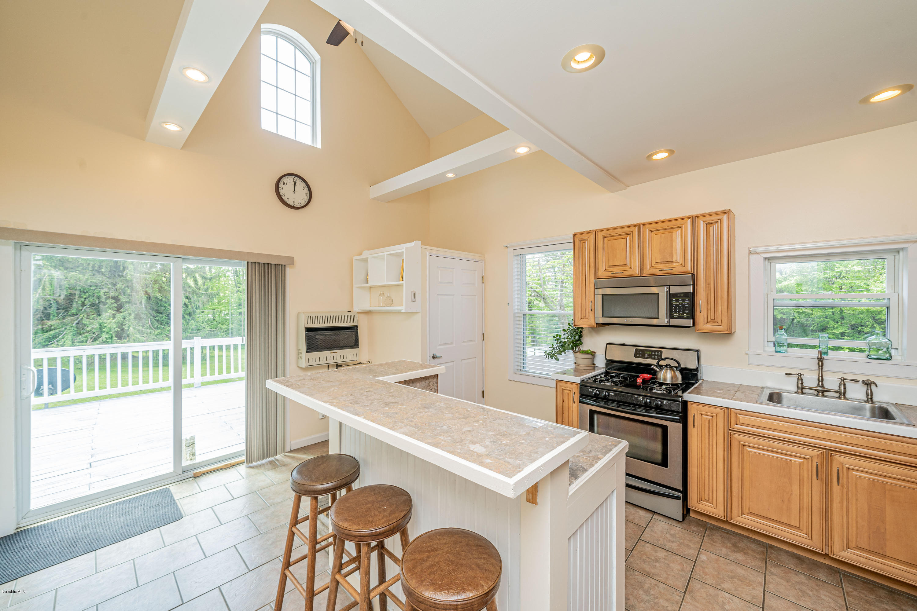 22 Wade Inn Road Becket, MA 01223 - Photo 5 of 32 a kitchen that has a sink a stove top oven a dining table and chairs