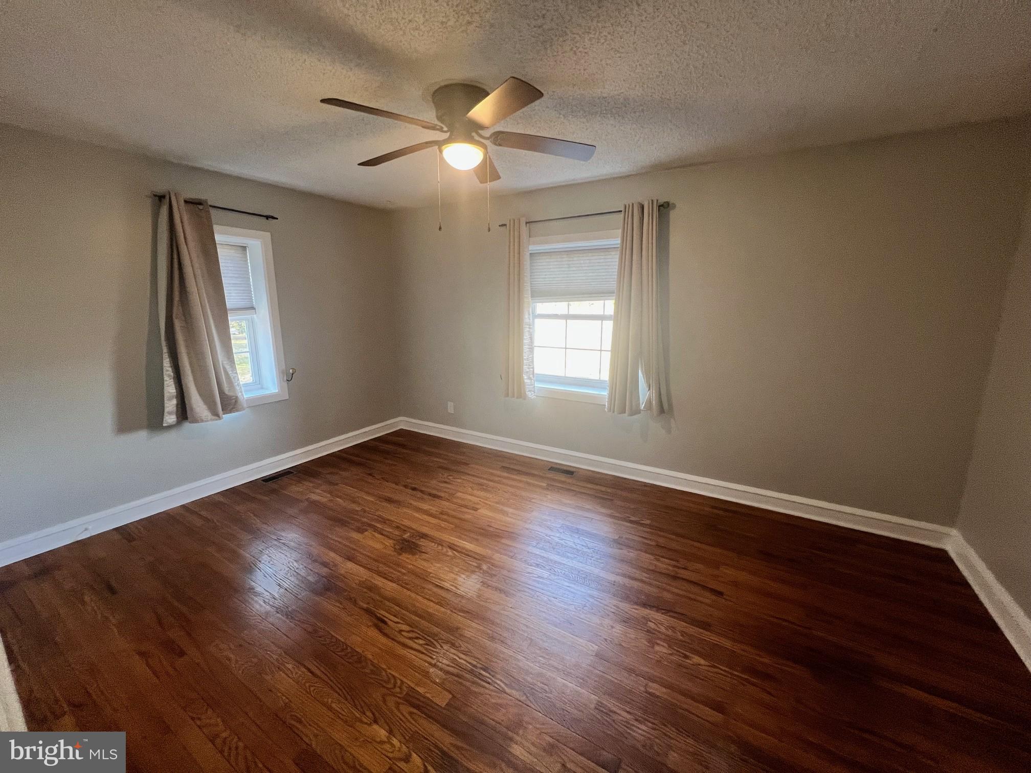 1355 Harding Highway Newfield, NJ 08344 - Photo 13 of 18 a view of an empty room with wooden floor and a window