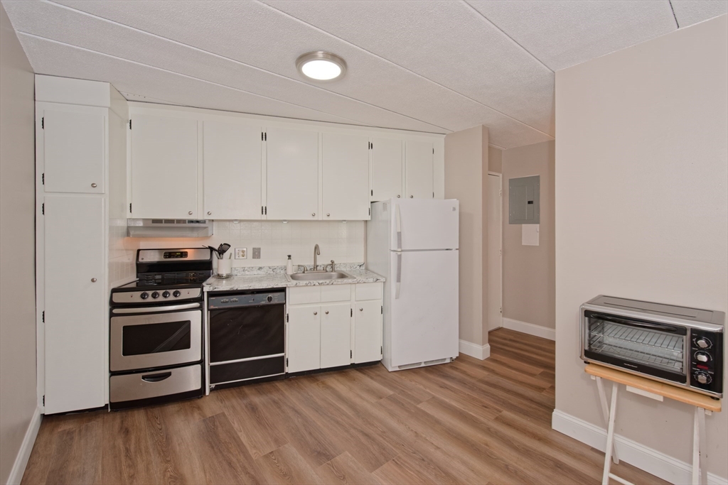 147 Turner Road, Unit 97 Holliston, MA 01746 - Photo 12 of 30 a kitchen with cabinets stainless steel appliances and wooden floor