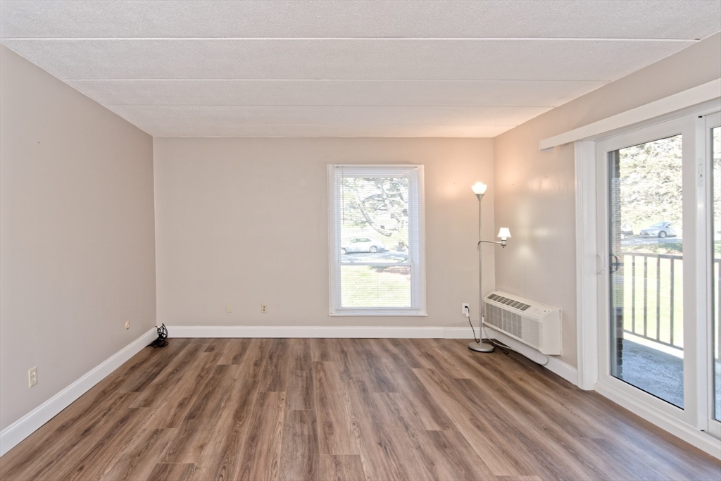 147 Turner Road, Unit 97 Holliston, MA 01746 - Photo 8 of 30 an empty room with wooden floor and windows