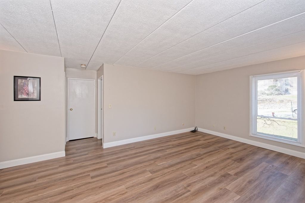147 Turner Road, Unit 97 Holliston, MA 01746 - Photo 10 of 30 an empty room with wooden floor and windows