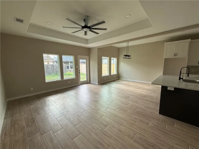 a view of a livingroom with a ceiling fan and wooden floor
