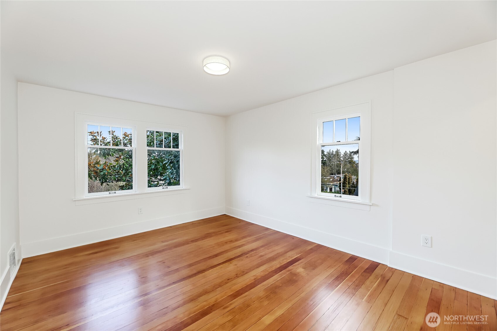 2207 East Republican Street Seattle, WA 98112 - Photo 11 of 24 a view of an empty room with wooden floor and a window