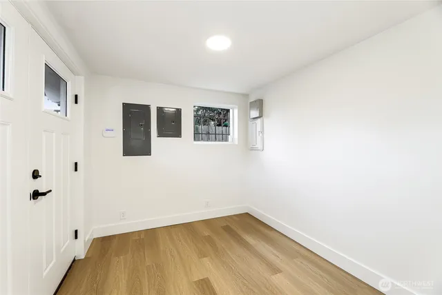 a view of a room with wooden floor and white walls