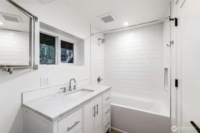 a bathroom with a shower sink vanity and mirror