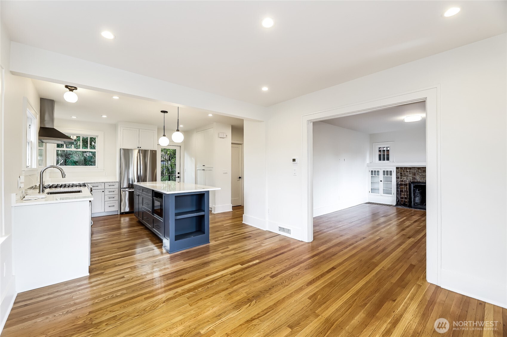 2207 East Republican Street Seattle, WA 98112 - Photo 2 of 24 a large living room with stainless steel appliances kitchen island a stove a refrigerator cabinets and living room view