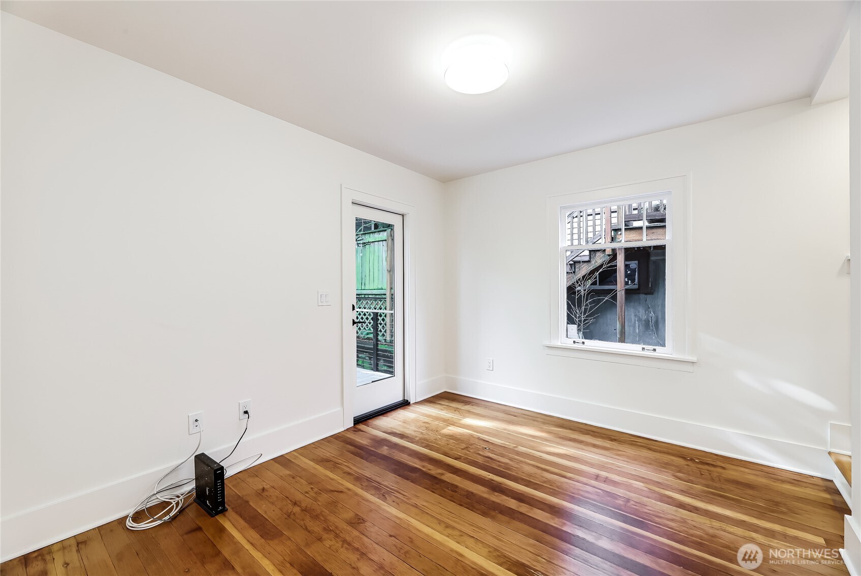 2207 East Republican Street Seattle, WA 98112 - Photo 5 of 24 an empty room with wooden floor and windows